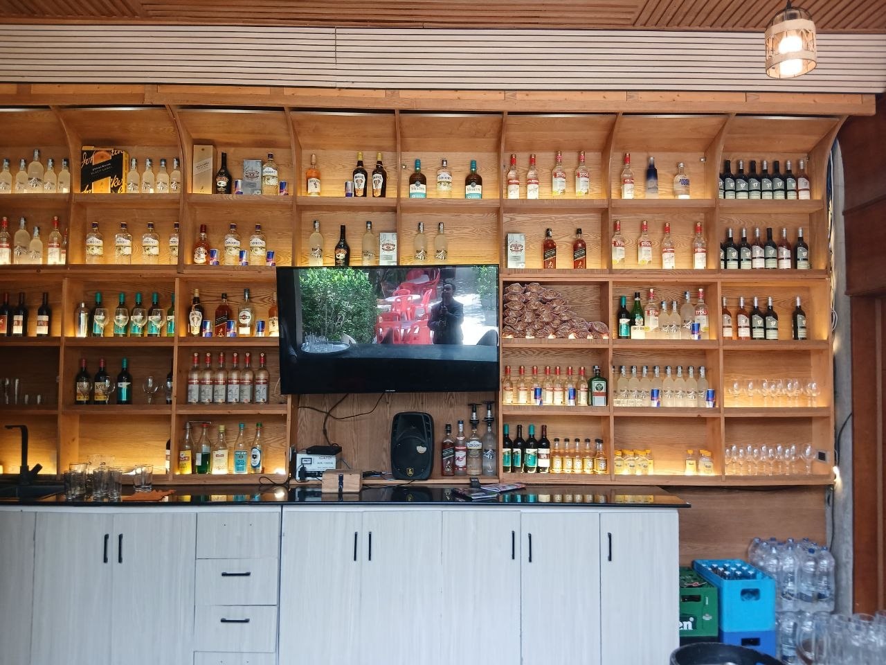 The fully stocked bar at Hordofa Lodge with backlit timber shelves